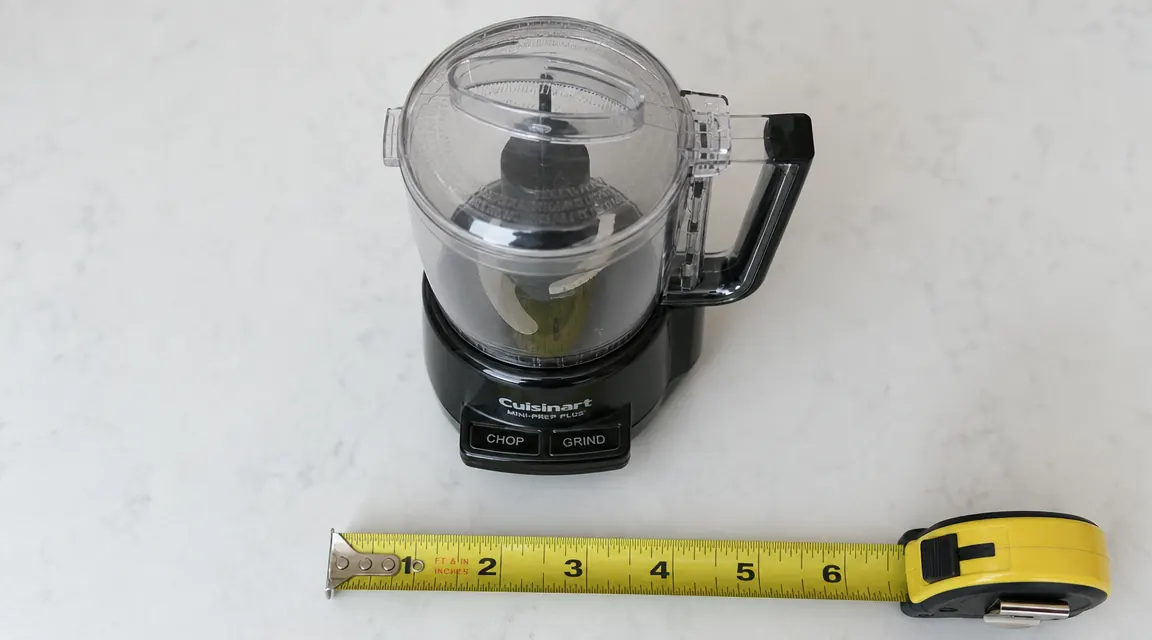 Mini food processor next to a tape measure showing it occupies about 6 inches of counter width